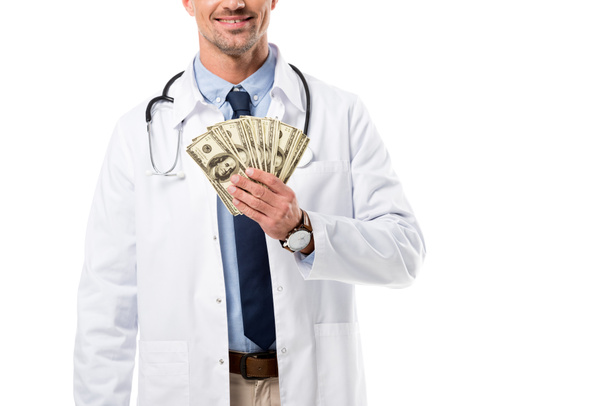 vista recortada de sonriente médico sosteniendo billetes de dólar aislados en blanco, concepto de seguro de salud
 - Foto, Imagen