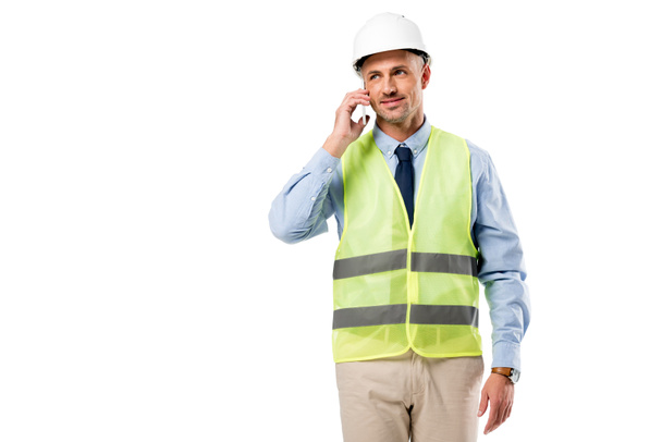 Ingeniero guapo en casco hablando en teléfono inteligente aislado en blanco
 - Foto, Imagen