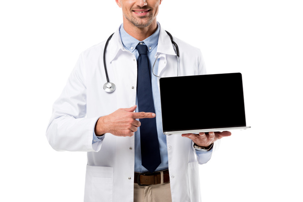 vista recortada del médico apuntando con el dedo a la computadora portátil con pantalla en blanco aislado en blanco
 - Foto, Imagen