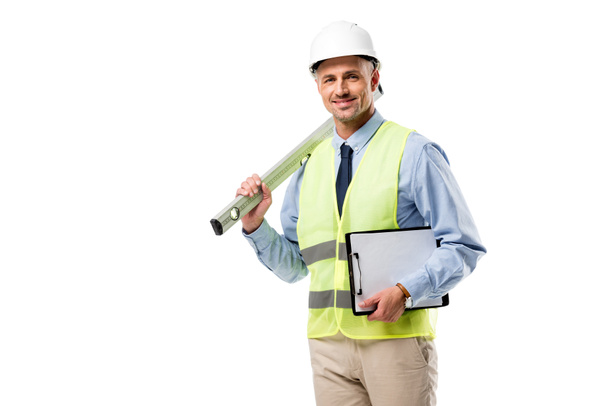 smiling engineer holding clipboard and spirit level isolated on white - Foto, imagen