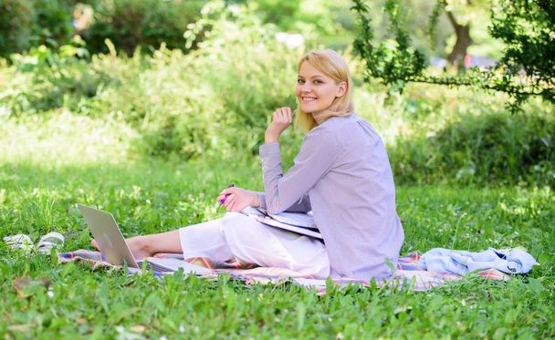 Woman with laptop sit grass meadow. Best jobs to work remotely. Business lady freelance work outdoors. Remote job concept. Stay free with remote job. Managing business remote outdoors - Foto, Bild