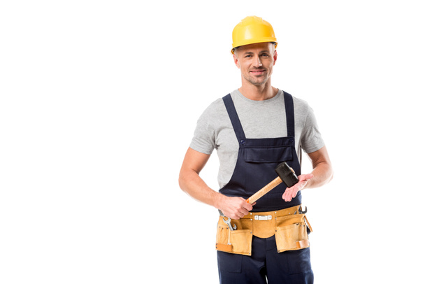 trabajador de la construcción en casco mirando a la cámara y sosteniendo martillo aislado en blanco
 - Foto, Imagen