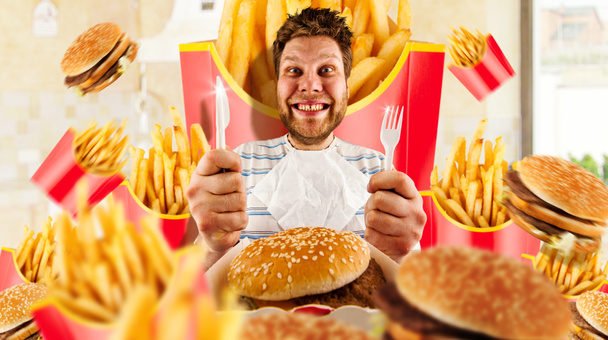 Fast food fogalom, az ember és a hamburgerek sült krumplival. Őrült férfi, akit a kést és a villát arra készül, hogy eszik - Fotó, kép