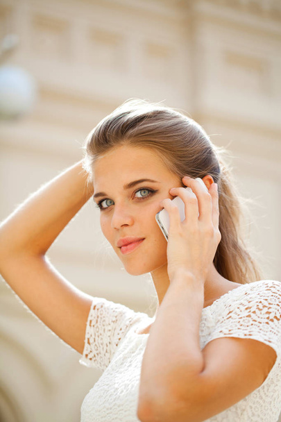 Portrait of a beautiful young woman calling by phone in shop - Foto, Imagen