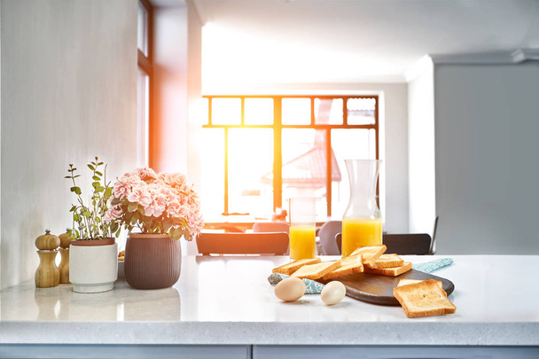 Portion de toasts sur une planche de bois avec du jus d'orange. Le petit déjeuner est servi sur une table avec une serviette bleu clair
. - Photo, image
