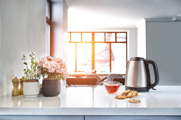 Śniadanie sceny w słoneczny poranek. Przezroczysty kubek czarny z herbatniki na stole w kuchni - Zdjęcie, obraz