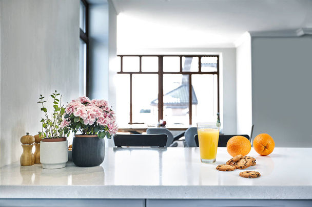 Chutný sladký pomerančový džus a jedna sklenice stojí na bílém stole v kuchyni na snídani. - Fotografie, Obrázek