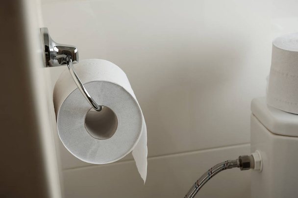 Suporte com rolo de papel higiênico macio na parede no banheiro
 - Foto, Imagem