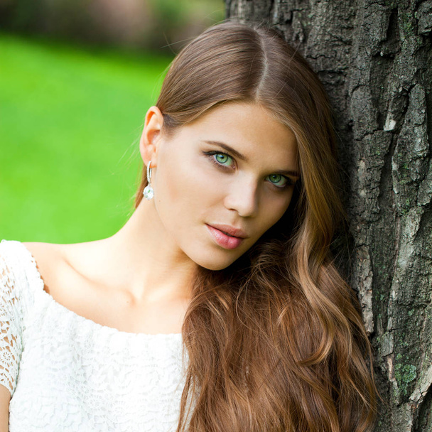 Portrait close up of young beautiful woman, on green background summer nature - Foto, immagini
