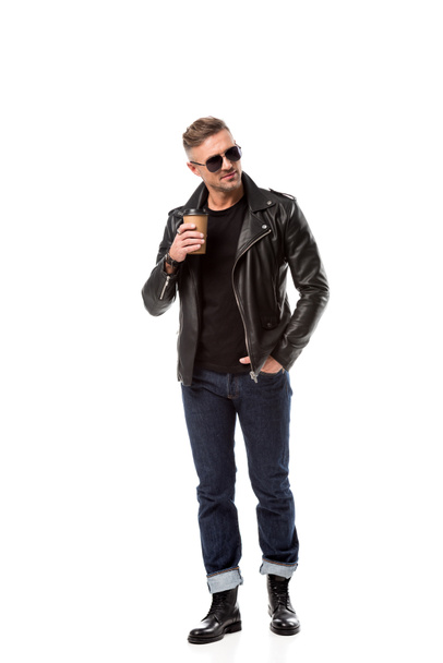 stylish adult man in leather jacket with hand in pocket drinking coffee to go isolated on white - Photo, Image