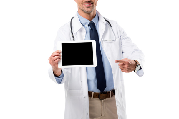 Vista ritagliata del medico sorridente che punta con il dito al tablet digitale con schermo bianco isolato su bianco
 - Foto, immagini