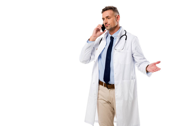 knappe dokter praten over smartphone geïsoleerd op wit - Foto, afbeelding