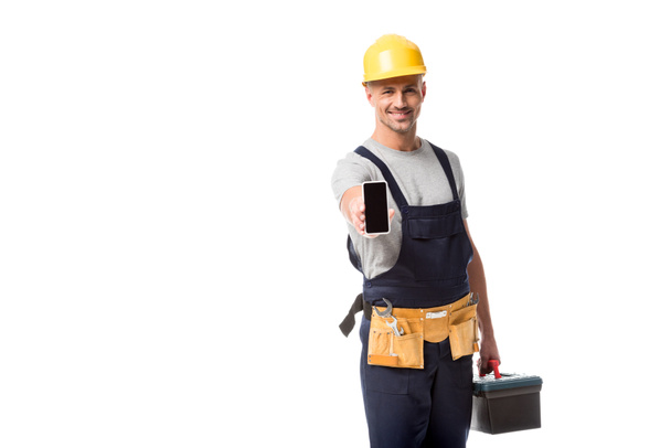 construction worker in hard hat presenting smartphone with blank screen isolated on white - Fotografie, Obrázek