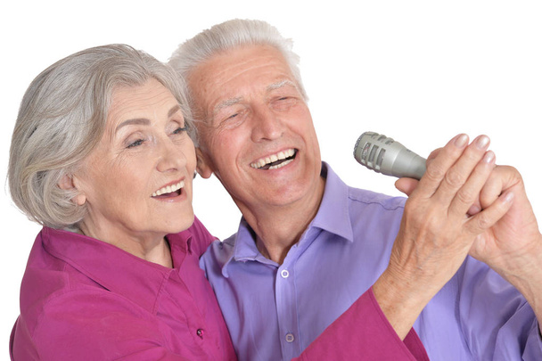 Senior couple singing karaoke isolated on white background - Foto, imagen