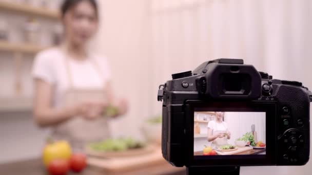 Bloggerin asiatische Frau mit Kamera Aufzeichnung, wie Salat gesunde Ernährung Video für ihre Abonnenten zu machen, verwenden Frauen Bio-Gemüse Zubereitung Salat für einen fitten Körper zu Hause. gesundes Ernährungskonzept. - Filmmaterial, Video
