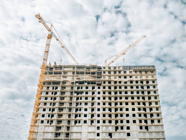 Building of multiroom inhabited highly floor house. Cranes on a construction site - Фото, зображення