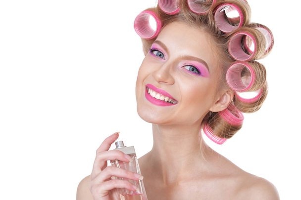 portrait of Beautiful  woman with hair curlers with perfumes  - Фото, изображение