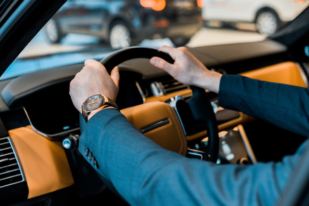 image recadrée de l'homme d'affaires avec montre de luxe assis dans l'automobile
 - Photo, image