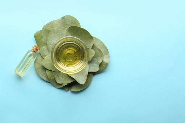 Botella y tazón de aceite esencial de eucalipto sobre fondo de color
 - Foto, imagen