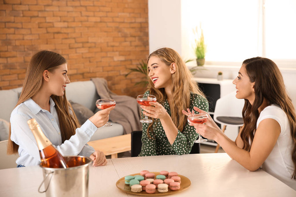 Kauniita nuoria naisia juomassa samppanjaa kotona
 - Valokuva, kuva