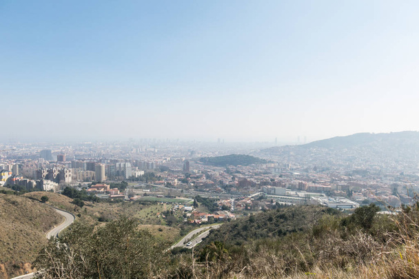 Overview of the polluted city of Barcelona, from the Collserola mountain, with a layer of smog over it. Barcelona, Catalonia, Spain - Фото, изображение