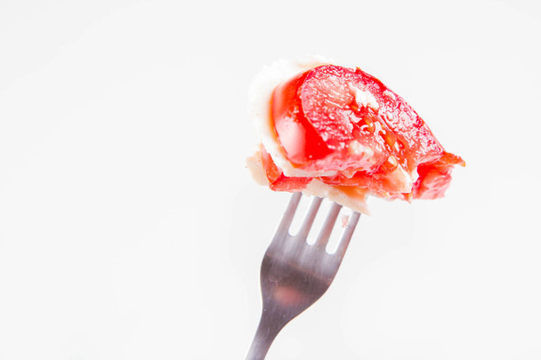 Caprese salad - tomato with mozzarella on a fork on a white background - Foto, Imagem