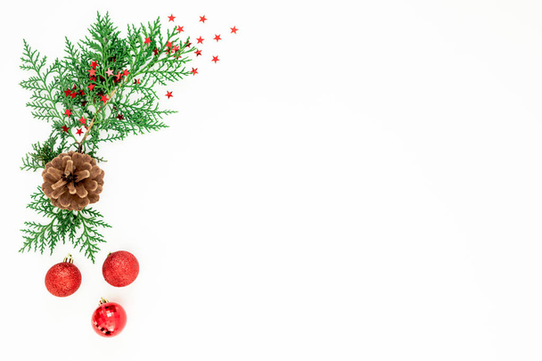 Moldura de Natal de ramos e bolas vermelhas decoração com confete no fundo branco. Fundo festivo. Deitado plano, vista superior
 - Foto, Imagem