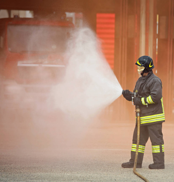 Пожарный использует мощную пену, чтобы потушить огонь.
 - Фото, изображение