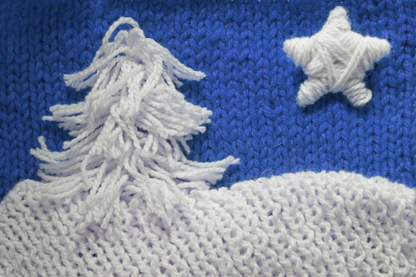 Hadmade Christmas tree and star on blue knitted woolen background with copy space for text Christmas concept - Photo, image