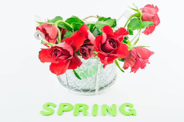 Rode rozen in de voorzijde die de Engels woord lente - Foto, afbeelding