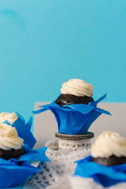 pohled z čokoládové dorty s bílým krémem na modré a šedé pozadí na plochu - Fotografie, Obrázek