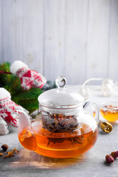 Glas-Teekanne mit Blumen gebundenen Tee, heißer Tee in Glas Teekanne und Honig mit Metall-Honig-Stick auf Steinhintergrund, Weihnachtskonzept - Foto, Bild