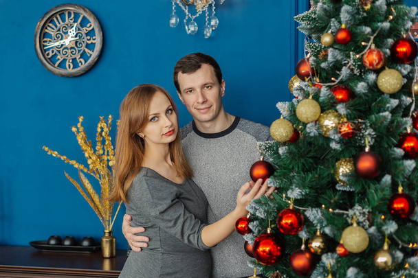 Very beautiful couple in love standing and hugging in a New Years room with decor. - Photo, Image