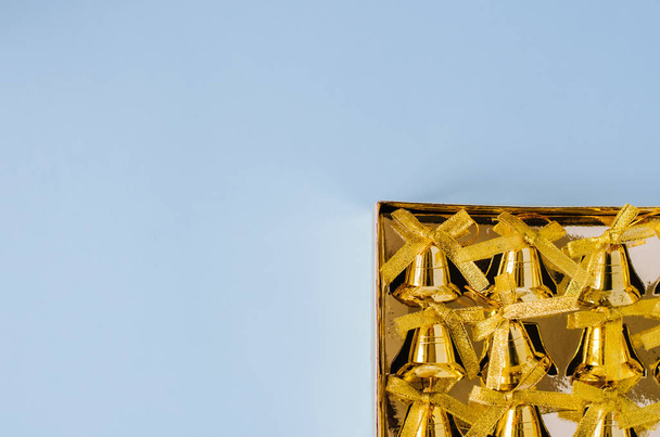Κουτί με χρυσές καμπάνες σε μπλε φόντο. - Φωτογραφία, εικόνα