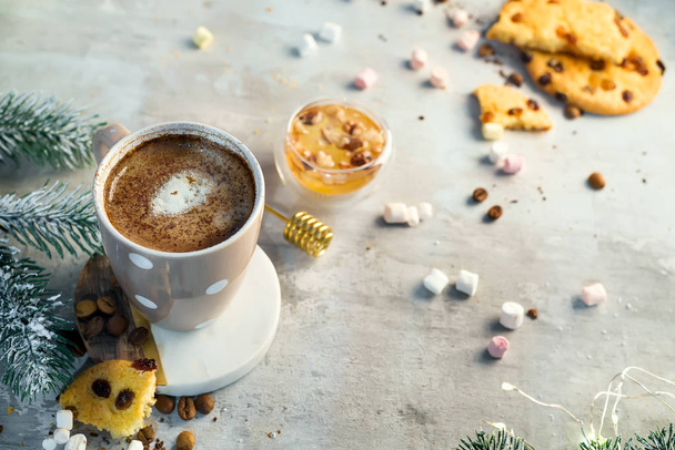 Кофейная чашка с шоколадным печеньем на каменном фоне с медом и металлической медовой палочкой с копировальным местом. Рождественская концепция
 - Фото, изображение