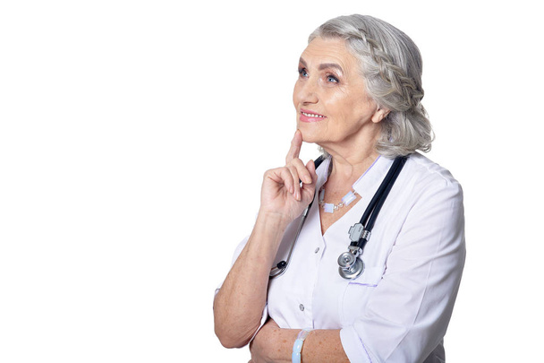 Portrait of a beautiful senior female doctor posing against white background - Фото, зображення