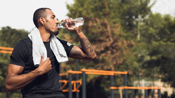 Uomo sportivo che beve acqua dopo l'allenamento fuori
 - Foto, immagini