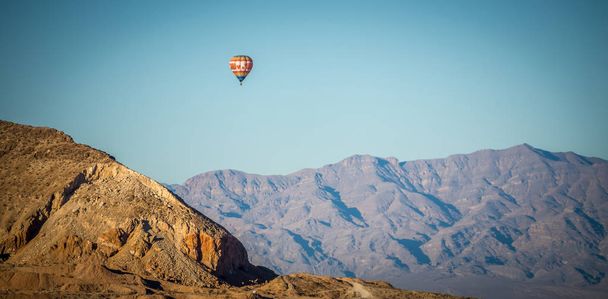 Heißluftballon fliegt über roter Felsenschlucht - Foto, Bild