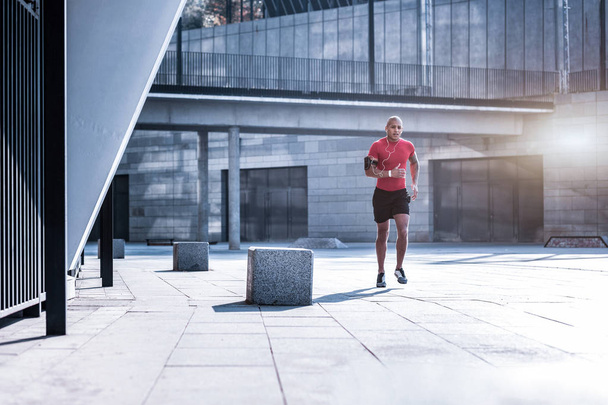 schöner, athletischer Mann läuft durch die Stadt - Foto, Bild