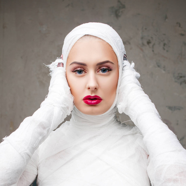 Glamorous mummy. Portrait of a young beautiful woman in bandages all over her body - Fotografie, Obrázek
