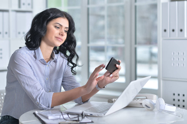 young woman with phone  working in  office - Photo, Image