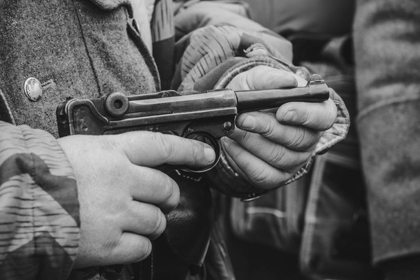 Parabellum pistooli lähikuva käsissä
 - Valokuva, kuva