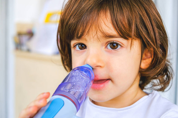 bebê resfriado comum leva lavagem nasal com dispositivo de irrigação nasal
 - Foto, Imagem