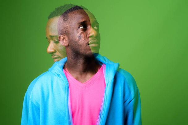 Διπλή έκθεση shot νεαρού άνδρα αφρικανική ενάντια σε πράσινο φόντο - Φωτογραφία, εικόνα