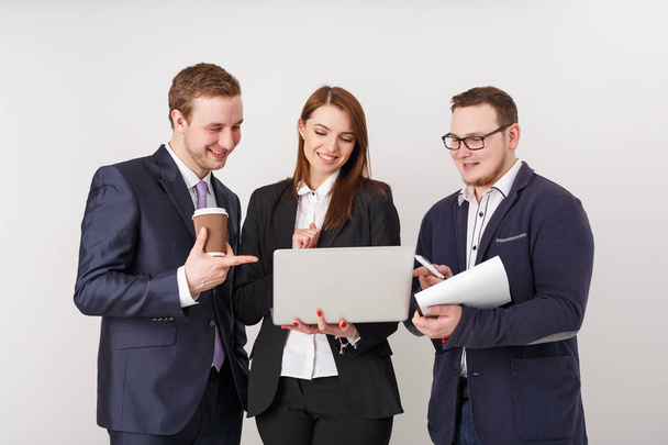 Business people looking at laptop and smiling - Photo, Image