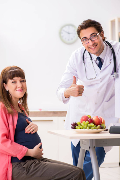 Pregnant woman visiting doctor discussing healthy diet - Photo, Image