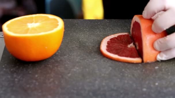 Šéfkuchaře ruce řezání čerstvého grapefruitu na kuchyň. Zpomalený pohyb, detail - Záběry, video