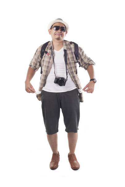 Conceito de viajante. Retrato de mochileiro asiático masculino turista vestindo chapéu, óculos de sol pretos, câmera e mochila isolada em branco. Retrato de corpo inteiro. Carteira vazia quebrada
 - Foto, Imagem
