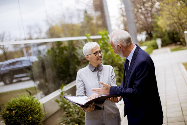 Ältere oder ältere Geschäftsleute sprechen im Freien und diskutieren ein Dokument - Foto, Bild