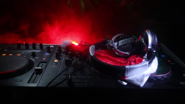 Dj mixer with headphones on dark nightclub background with Christmas tree New Year Eve. Close up view of New Year elements on a Dj table. Holiday party concept. Empty space - Footage, Video